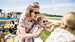 Lady and child watching the horseracing at family raceday, Goodwood Racecourse. 